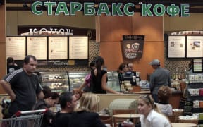 Customers buy and drink coffee on opening day of Russia's first Starbucks in Moscow, 06 September 2007. Starbucks is hoping cash in on the Russian market despite the fact that several Russian coffee house chains are already widespread.        AFP PHOTO / NATALIA KOLESNIKOVA (Photo by NATALIA KOLESNIKOVA / AFP)
