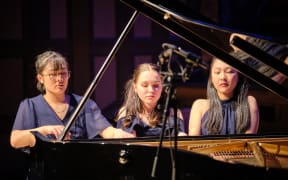 Three pianists at one piano, Schnittke's Snickers perform on stage at Auckland Town Hall