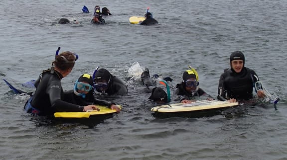 Experiencing Marine Reserves co-ordinators Zoe Studd (left, with back to camera) and Liz Gibson return to the beach with their enthusiastic students.