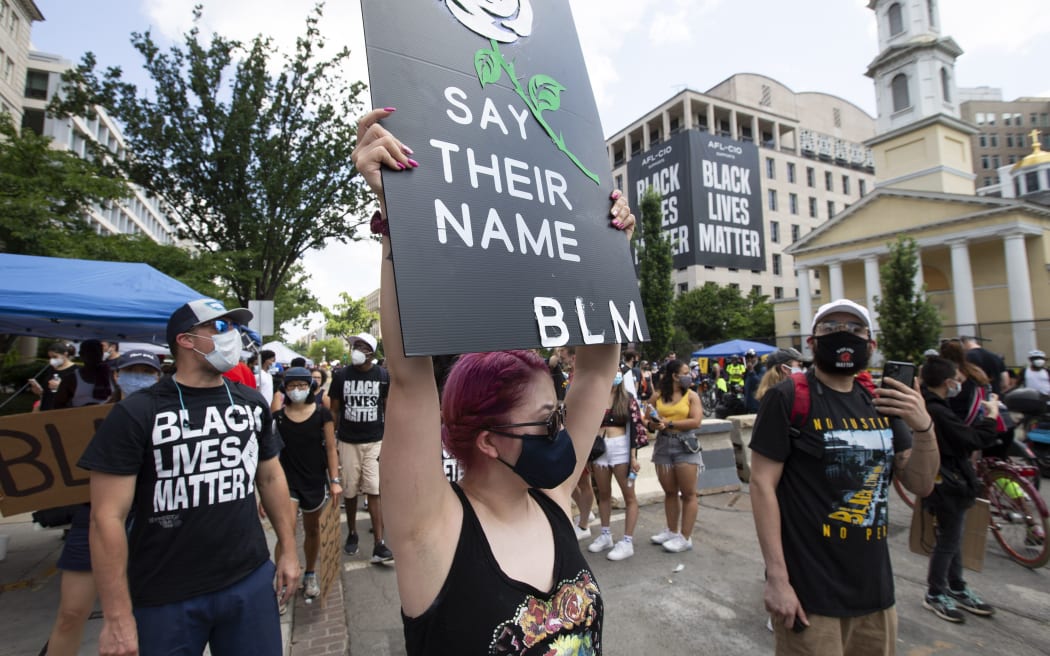 Demonstrators march near the White House and St, John's Church (R) ahead of the Fourth of July celebration on July 4, 2020, in Washington, DC.