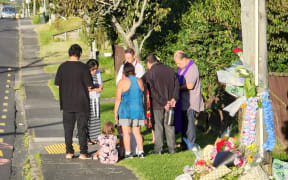 A pastor and a group of friends and locals say prayers on Sunday following the death of Joshuah Tasi, 28, on Friday night.