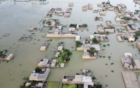 An aerial photograph taken on 5 September, 2022 shows flooded residential areas after heavy monsoon rains in Dera Allah Yar, in Pakistan's Balochistan province. Nearly a third of Pakistan is under water - an area the size of the United Kingdom - following months of record monsoon rains that have killed 1,300 people and washed away homes, businesses, roads and bridges.