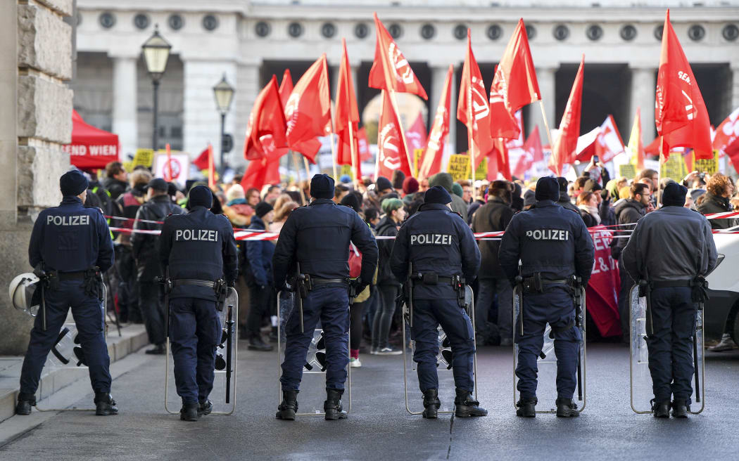 Riot policemen hold a barricade during a protest against the new Austrian government.