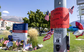 US flags and a sign to honor Charlie Kirk are seen at a memorial set up outside of Timpanogos Regional Hospital in Orem, Utah, on September 11, 2025. The gunman who shot dead US right-wing youth leader Charlie Kirk in a targeted killing remained at large Thursday but authorities said they have video images of the suspect and have recovered a "high-powered" rifle. Kirk, a 31-year-old superstar on the Republican right who was credited with helping Donald Trump return to the presidency last year, was shot while addressing a large crowd at Utah Valley University on Wednesday. (Photo by Melissa MAJCHRZAK / AFP)