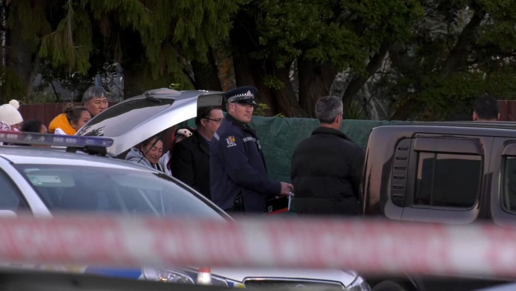 Police speak with a group of people inside the cordon on Favona Road, where a two-year-old girl was found dead on 2 June 2016.
