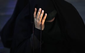 An Iranian woman prays for President Ebrahim Raisi in a ceremony at Vali-e-Asr square in downtown Tehran, Iran, Sunday, May 19, 2024. A helicopter carrying President Raisi, the country's foreign minister and other officials apparently crashed in the mountainous northwest reaches of Iran on Sunday, sparking a massive rescue operation in a fog-shrouded forest as the public was urged to pray. (AP Photo/Vahid Salemi)