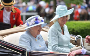 Britain's Queen Elizabeth II (C) and Britain's Camilla, Duchess of Cornwall (R) arrive by carriage on day two of the Royal Ascot horse racing meet, in Ascot, west of London, on June 19, 2019.