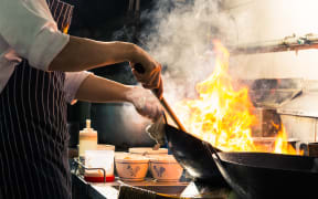 Chef is stirring vegetables in wok