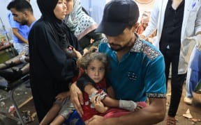 A wounded Palestinian girl is brought to be treated at the al-Awda Hospital in Nuseirat refugee camp after the Israeli military bombardment of the UNRWA (United Nations Relief and Works Agency for Palestine Refugees) run Abu Oreiban, turned shelter, where internally displaced Palestinians are living, in the Nuseirat camp, in the central Gaza Strip on July 14, 2024, amid the ongoing conflict between Israel and the Palestinian Hamas militant group.