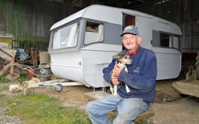 Jim Cowan with dog Bonnie outside their temporary home in Waipaoa. Following Cyclone Gabrielle, Cowan has been displaced from his home which was yellow stickered.