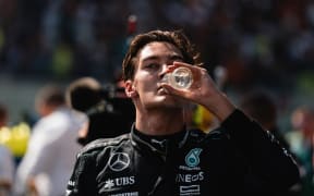 George Russell of Mercedes quenches his thirst at the Belgium Grand Prix, 28 July, 2024.