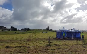 Police officers standing at the previous frontline, with occupiers who moved their tents camping further on in Ihumātao