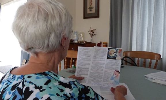 Back of head shot of  old woman reading FASD literature