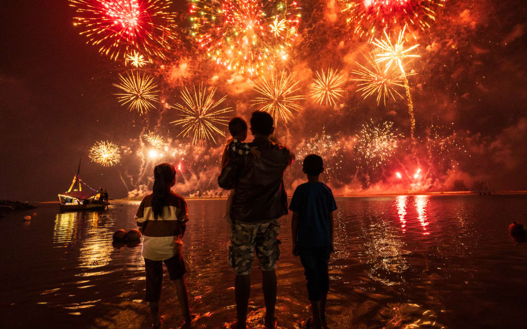 Local residents look at fireworks as they celebrate the New Year at Ancol Beach in Jakarta on January 1, 2025. (Photo by Yasuyoshi CHIBA / AFP)