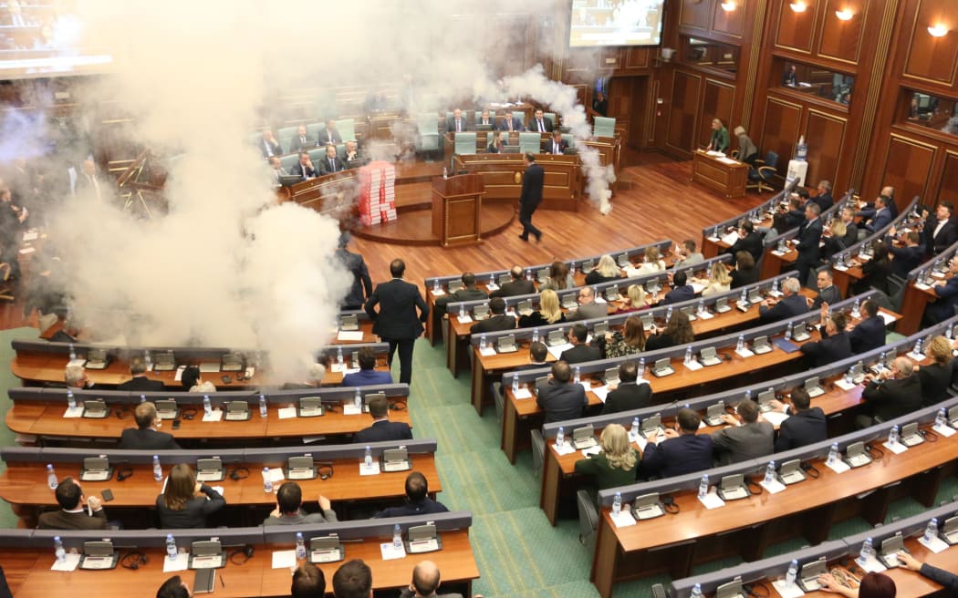 Members of the Self-Determination Movement party release a teargas canister during a parliamentary session in Pristina, Kosovo