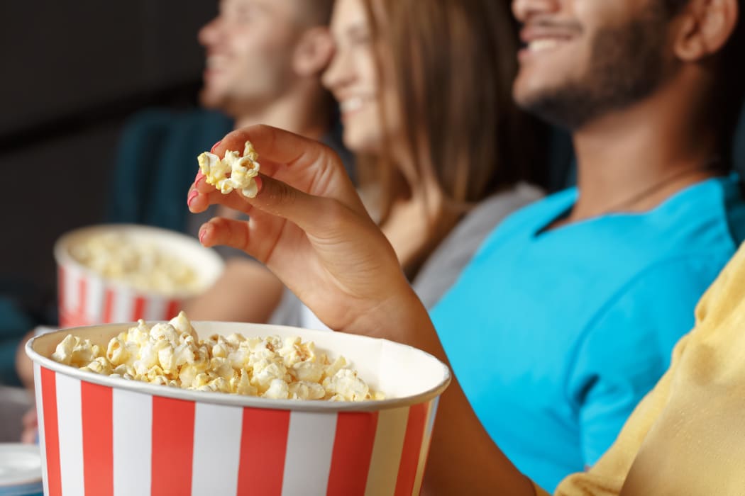 Group of people eating popcorn in the cinema