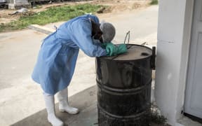 A hygienist rests as he waits outside a decontamination area in a COVID-19 coronavirus treatment centre that cares for positive patients that show little or no symptoms in Dakar.