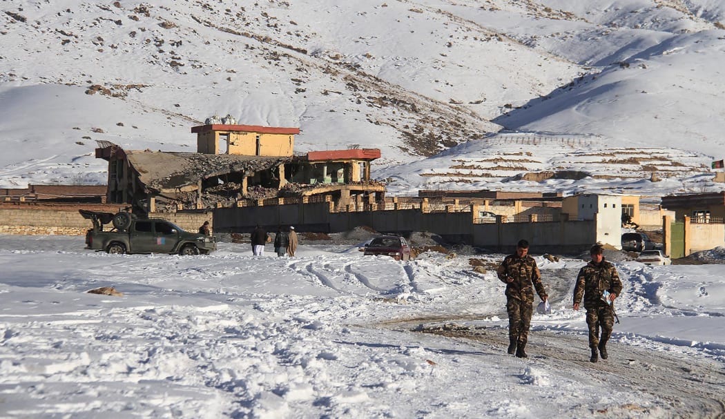Afghan security forces walks near a site after a car bomb attack on a military base in the central province of Maidan Wardak.