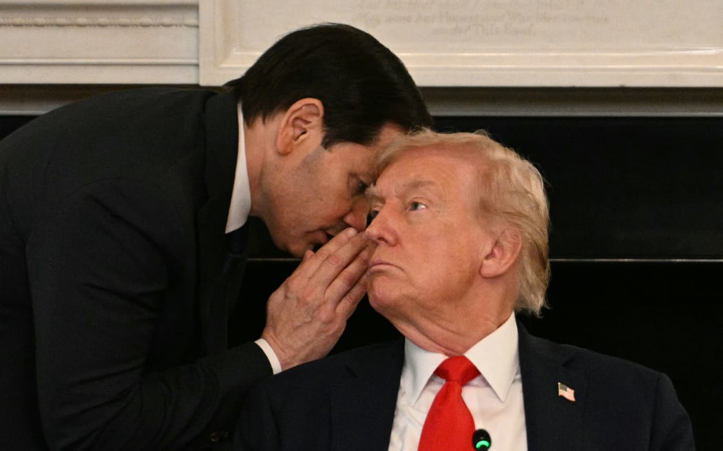 US Secretary of State Marco Rubio whispers in the ear of President Donald Trump during a roundtable about Antifa in the State Dining Room of the White House in Washington, DC, on October 8, 2025. (Photo by Jim WATSON / AFP)