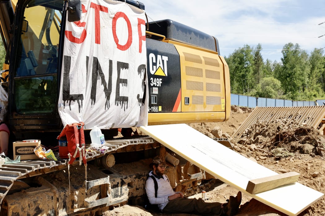 Environmental activists chain themselves to construction equipment at the Line 3 pipeline pumping station near the Itasca State Park, Minnesota on 7 June, 2021.