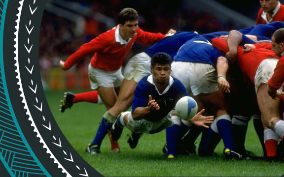 An image of a number of rugby players in red and blue uniforms in a scrum - Western Samoa in blue is playing Wales in red. The picture shows a Western Samoan player emerging from the melee with the ball between his hands. Its is Matthew Vaea of Western Samoa dive passing away from a scrum during the World Cup match against Wales at Cardiff Arms Park in Cardiff, Wales on October 6 1991.