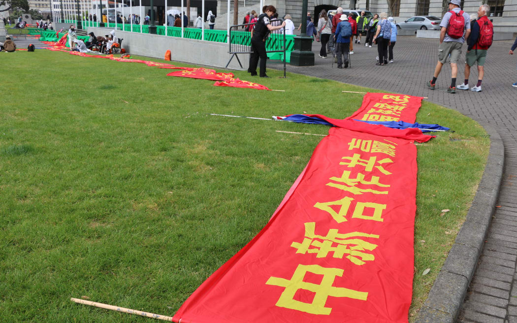 A small crowd of Chinese residents gathers outside Parliament on Thursday.