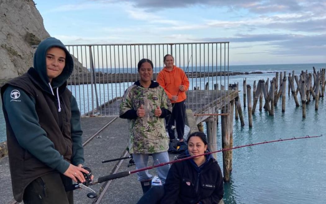Orini, Teraukura, Kalani and Lena fishing at the Tokomaru Bay wharf.