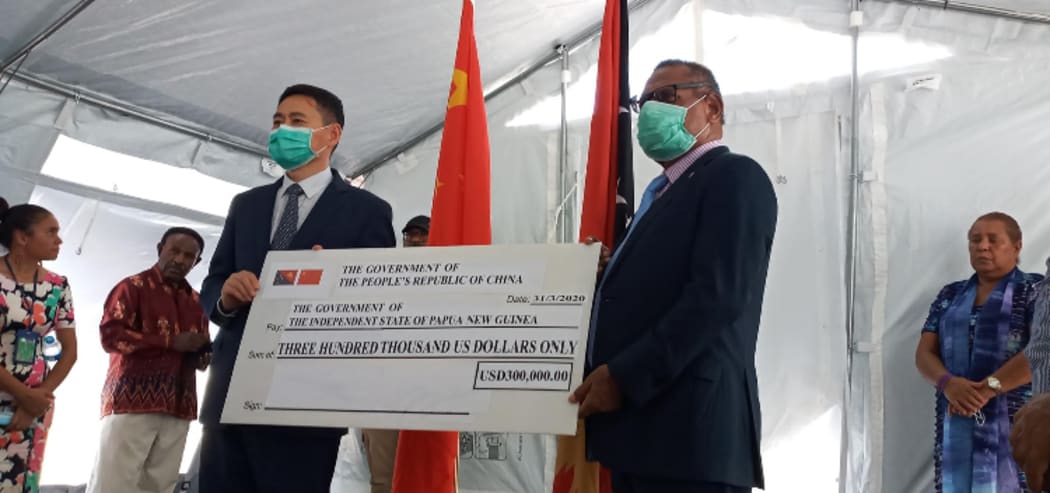 China's Ambassador in Papua New Guinea, Xue Bing, presents a cheque to PNG's Foreign Minister Patrick Pruaitch at Port Moresby General Hospital.