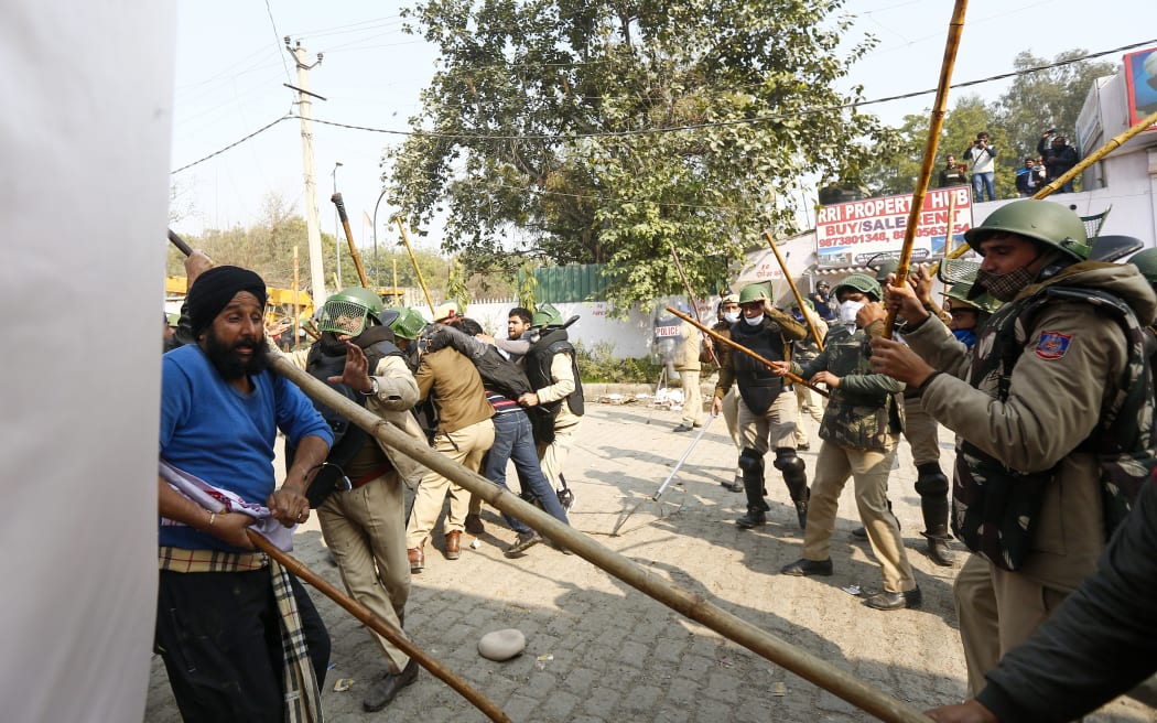 Indian police beat a farmer as they continue to protest against the central government's recent agricultural reforms blocking a highway at the Delhi-Haryana state border in Singhu on 29 January 2021.