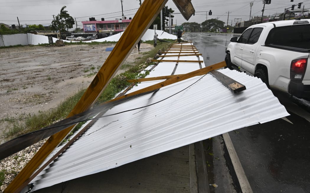 A blown down fence is seen in St. Catherine, Jamaica, on October 28, 2025. Ferocious winds and torrential rain tore into Jamaica Tuesday as Hurricane Melissa made landfall, the worst storm ever to strike the island nation and one of the most powerful hurricanes on record. The extremely violent Category 5 system was still crawling across the Caribbean, promising catastrophic floods and life-threatening conditions as maximum sustained winds reached a staggering 185 miles per hour (295 kilometers per hour). (Photo by Ricardo Makyn / AFP)