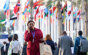 Participants walk on the allies of conference venue during the COP28, UN Climate Change Conference, held by UNFCCC in Dubai Exhibition Center, United Arab Emirates on December 4, 2023. COP28, running from November 30 to December 12 focuses on particular nations' decarbonisation goals. The Conference in Dubai focuses also on the most vulnerable communities and Loss and Damage (Photo by Dominika Zarzycka/NurPhoto) (Photo by Dominika Zarzycka / NurPhoto / NurPhoto via AFP)