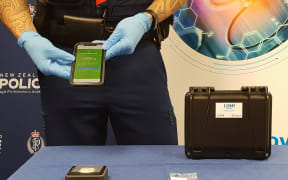 Constable Wepiha Te Kanawa showing how the new tool works. It screens through the packaging and send results to an app used exclusively by the police after connecting to ESR drug database.