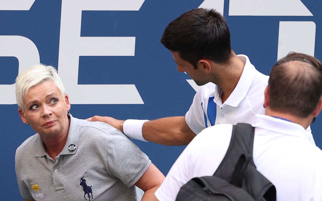 NEW YORK, NEW YORK - SEPTEMBER 06: Novak Djokovic of Serbia tends to a line judge who was hit with the ball during his Men's Singles fourth round match against Pablo Carreno Busta of Spain