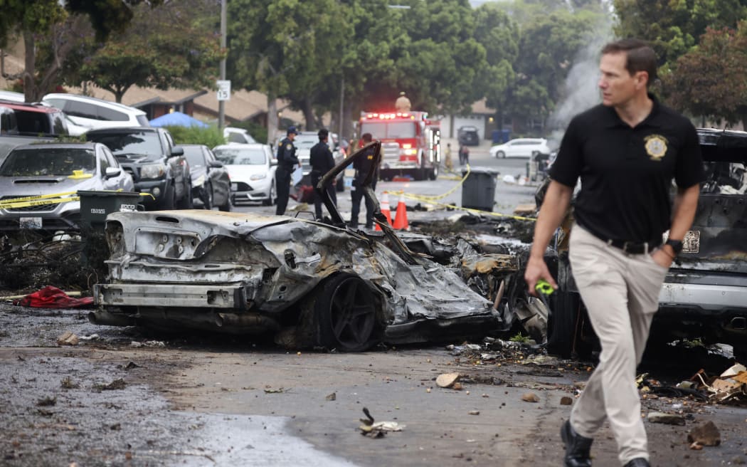 Investigators look through the site where a small plane crashed into San Diego, California, residential street on May 22, 2025. The Federal Aviation Authority said a Cessna 550 crashed at around 3:45 am local time. The neighborhood is close to the Montgomery-Gibbs Executive Airport. The crash left a "gigantic debris field" and damaged some 15 homes and parked cars, ABC News quoted the San Diego assistant fire chief as saying. (Photo by Sandy Huffaker / AFP)