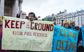 Campaigners urge companies at the  Paris summit to phase out fossil fuels.