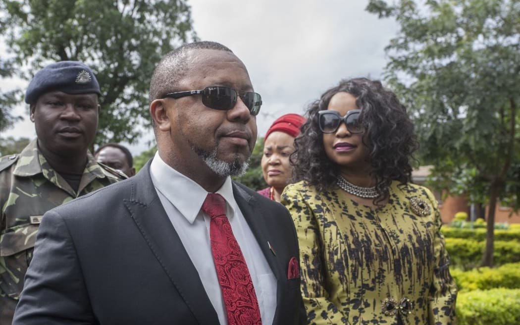 Former Malawi Vice President, Saulos Klaus Chilima (2nd L), who is now president for the United Transformation Movement (UTM) Party and who is the first petitioner in the Malawi Elecions Case, is accompanied by his wife Mary Chilima (R), waits to be screened at the Lilongwe High Court, where constitutional court judges will preside over the ruling on whether to annul the controversial vote that saw Malawi President Peter Mutharika re-elected in the May 2019 election, in Lilongwe on February 3, 2020. (Photo by AMOS GUMULIRA / AFP)