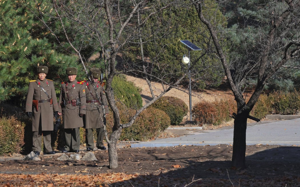 This file photo taken on November 27, 2017 shows North Korean soldiers staring at the South side at the truce village of Panmunjom in the DMZ.