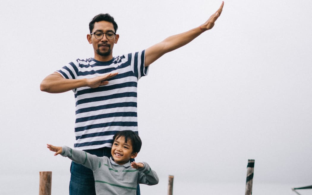 father and son play on a dock