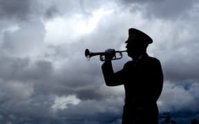 Silhouette of a man playing taps on his bugle at a veterans funeral at Medical Lake Veterans Memorial in Washington.