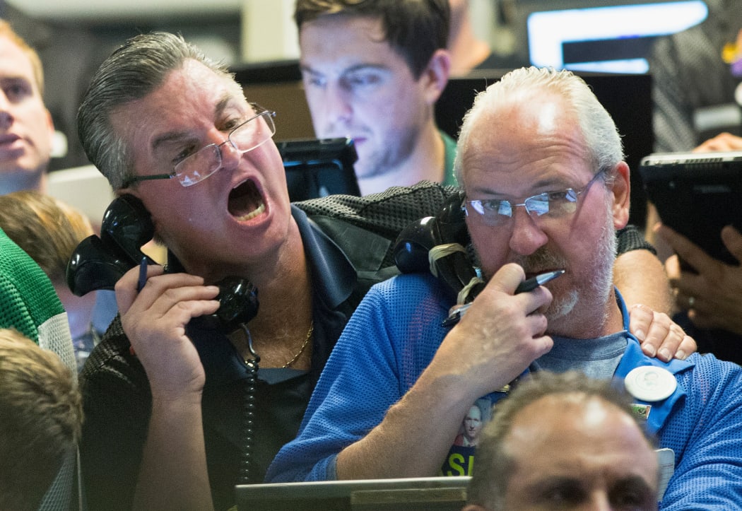 Traders at the Chicago Board Option Exchange work as big losses in the Asian market rock stocks.