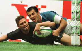 Glen Osborne slides in the tackle of Italy's Christian Stocia to score in the final pool match of the Rugby World Cup at McAlpine Stadium, Huddersfield.