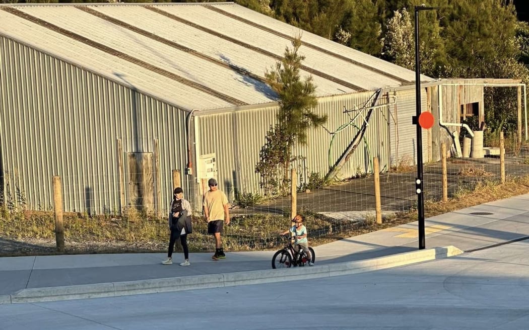 A protestor slept on the closed-off roundabout while residents waited for AT to paint road markings so it could be opened.