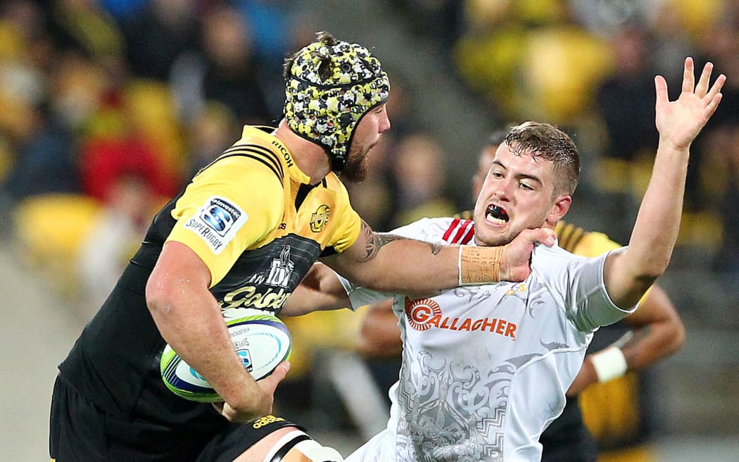 Hurricanes' Blade Thomson fends off Chiefs' Rhys Marshall during a Super rugby match in 2016.