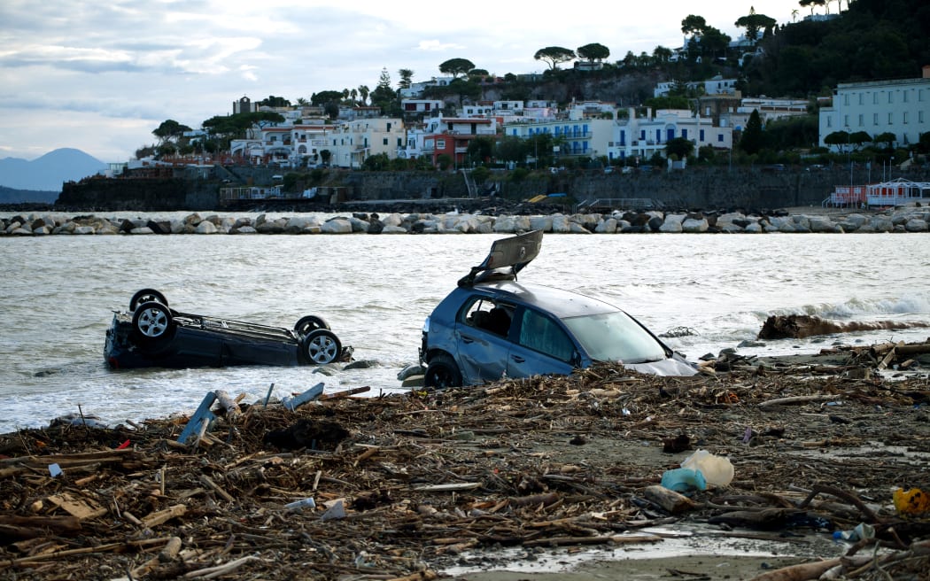 Damaged cars are seen on the beach of Casamicciola on November 27,2022, following heavy rains that caused a landslide on the island of Ischia, southern Italy. - Italian rescuers were searching for a dozen missing people on the southern island of Ischia after a landslide killed at least one person, as the government scheduled an emergency meeting. A wave of mud and debris swept through the small town of Casamicciola Terme early Saturday morning, engulfing at least one house and sweeping cars down to the sea, local media and emergency services said. (Photo by Eliano IMPERATO / AFP)