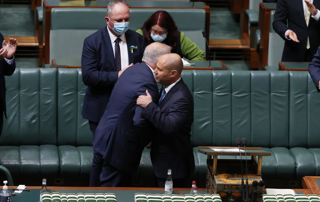 Australian Treasurer Josh Frydenberg hugs Prime Minister Scott Morrison (L) after delivering his 2022 Budget in Parliament House in Canberra on March 29, 2022.