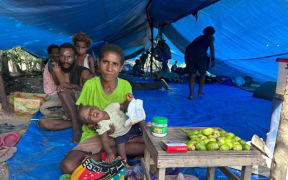 Evicted mother and baby selling betelnut in their temporary tent village on the outskirts of the capital, Port Moresby, PNG. Pictured on Mar. 16, 2025.