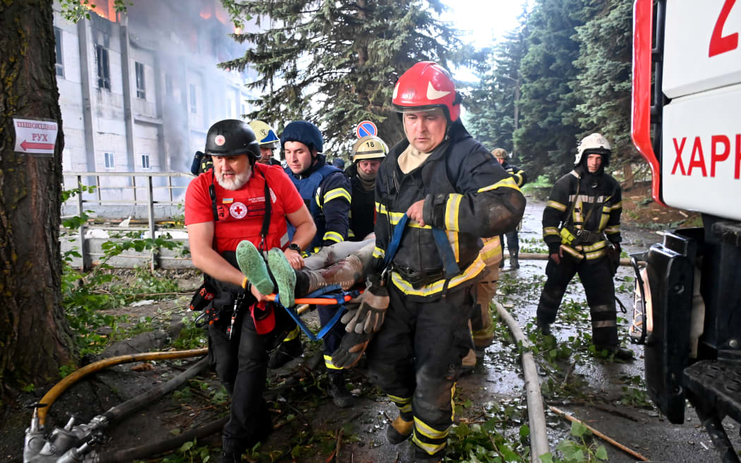 Rescuers carry a wounded person out of the ruins of a civilian plant following Russian powerful attacks on the Ukrainian city of Kharkiv early on June 7, 2025, amid the Russian invasion of Ukraine. Russia unleashed a barrage of missiles, drones and bombs across Ukraine early on June 7, killing at least five people in a major attack that the mayor of Kharkiv, Ukraine's second largest city, described as unprecedented. (Photo by SERGEY BOBOK / AFP)