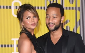 Model Chrissy Teigen and her husband, musician John Legend arrive on the red carpet at the MTV Video Music Awards (VMA), August 30, 2015 at the Microsoft Theater in Los Angeles, California.