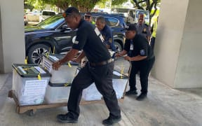 Police officers transport boxes containing postal absentee ballots from the main post office in Majuro to the election tabulation headquarters on December 4. Barely 40 percent of the absentee ballots mailed to offshore voters were returned in time to be tabulated. Photo: Hilary Hosia.