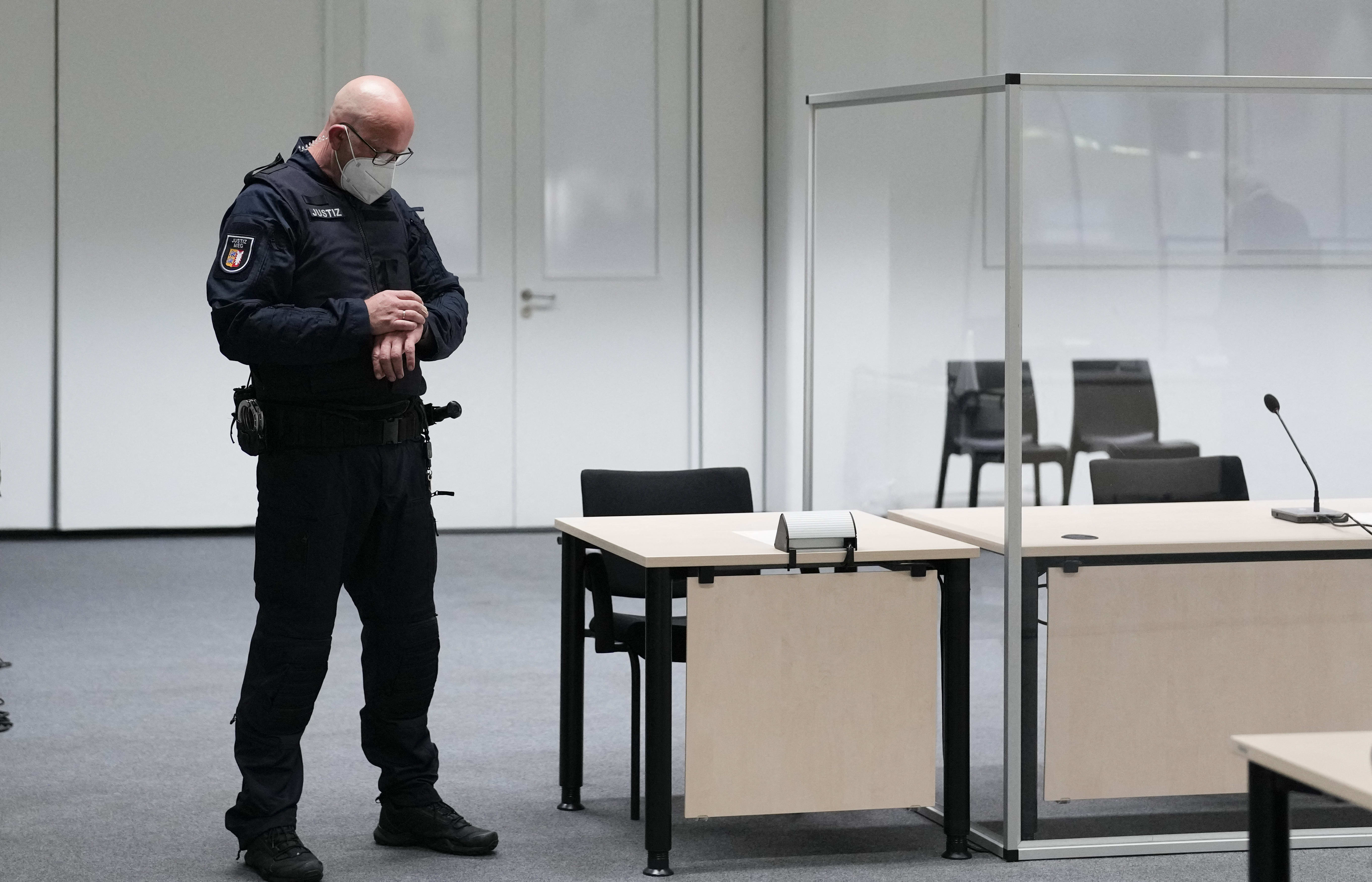 An official looks at his watch in the court room at Itzehoe before the trial of a 96-year-old former secretary to the SS commander of the Stutthof concentration camp.